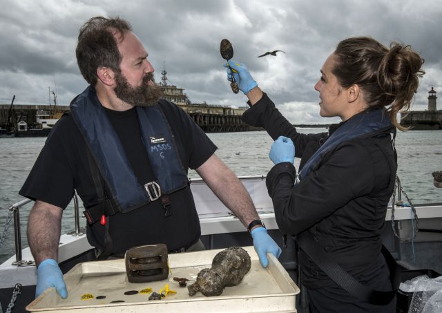 Conservation team members Elisabeth Kuiber and Eric Nordgren with finds including a spoon (Lauren Hurley/PA)