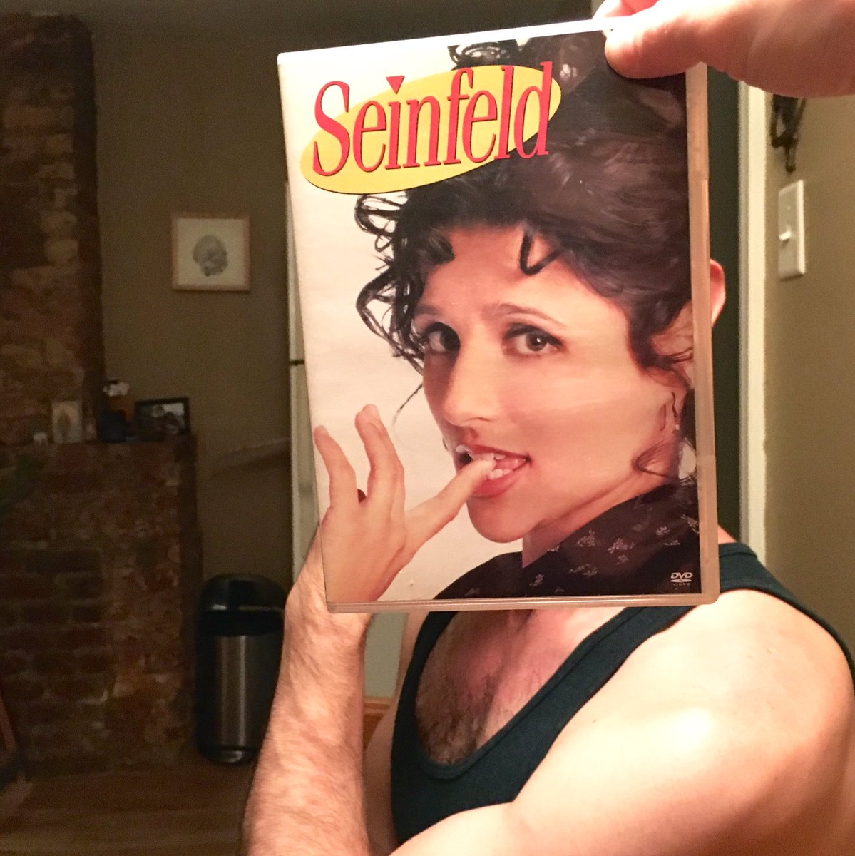 Ben O'Brien poses with the Seinfeld DVD sleeve as though he is Elaine (Ben O'Brien/Kelly Lasserre/Twitter)