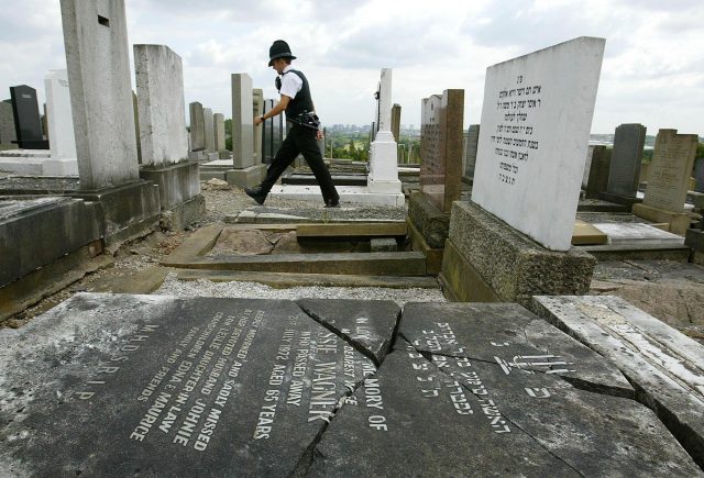 Police patrol a Jewish cemetery after vandals smashed gravestones (PA)