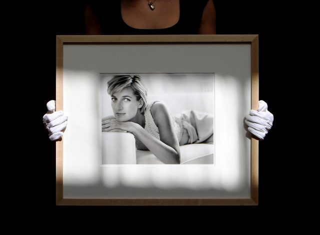 An employee at Christie's holds a photograph of Diana by Mario Testino