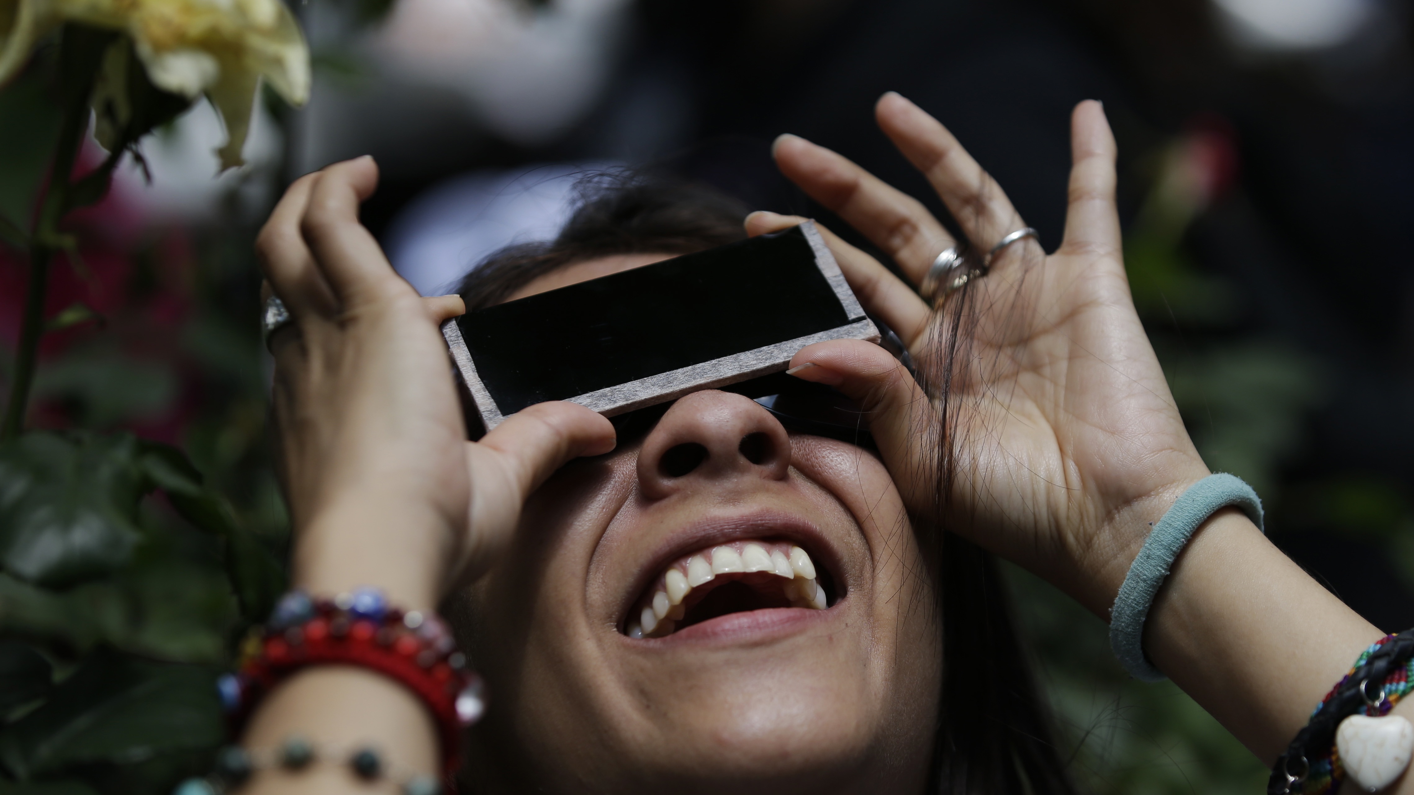 Someone watches a partial solar eclipse through a filter