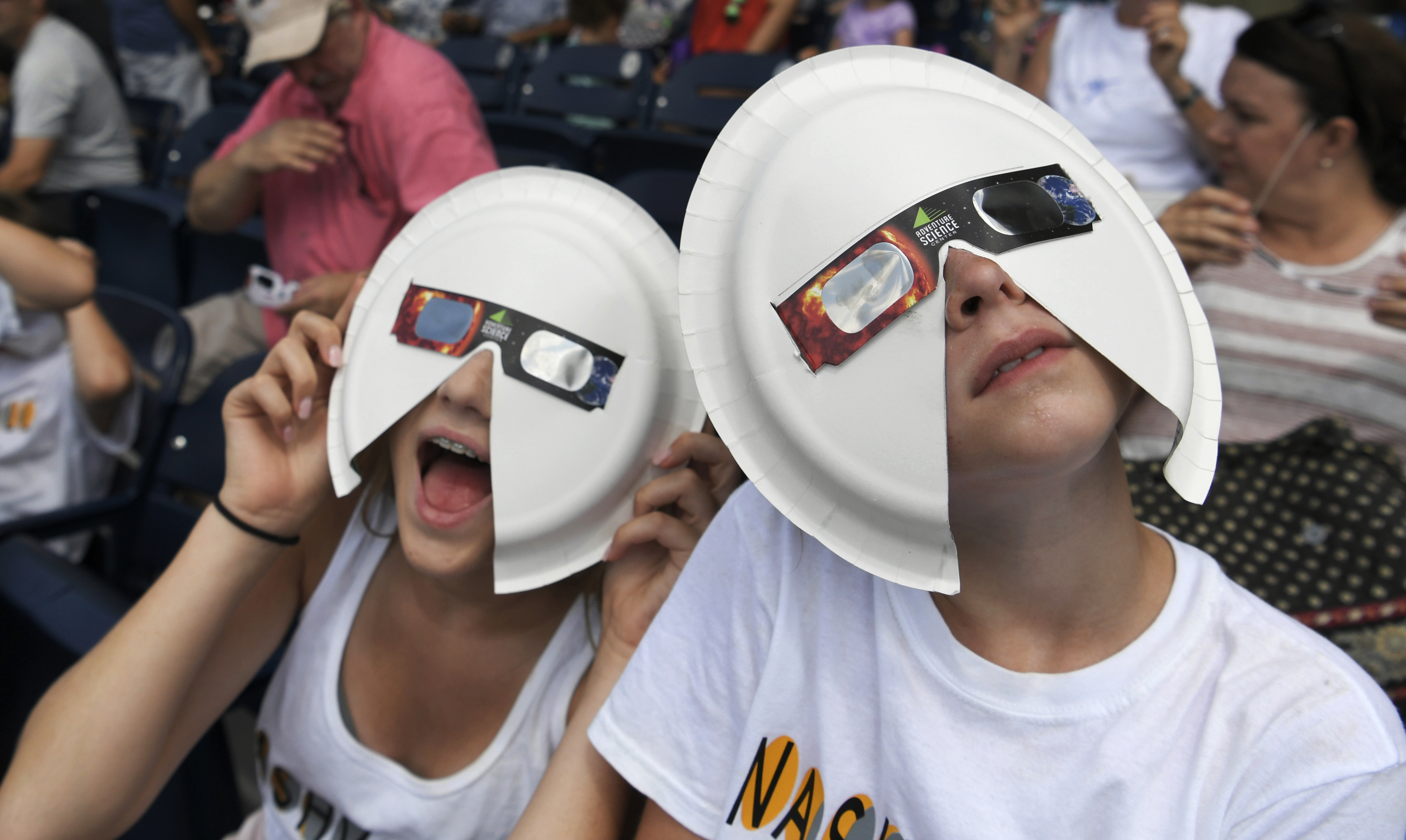 Two people wear makeshift eclipse glasses ahead of the solar eclipse