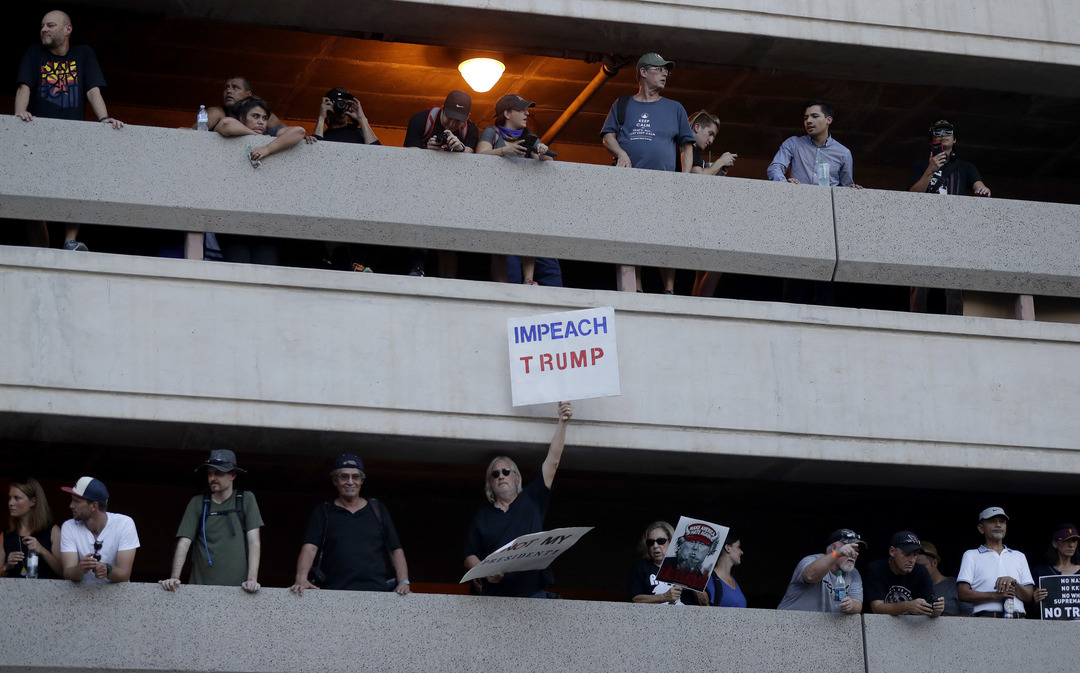 People protest from a parking garage outside the Phoenix Convention Center
