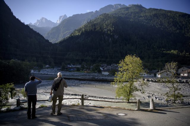 People watch the landslide that hit the village Bondo in Graubuenden in South Switzerland