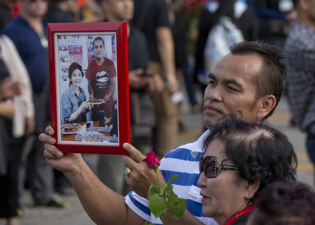A supporter of Thailand's former Prime Minister Yingluck Shinawatra displays a picture of her outside the Supreme Court