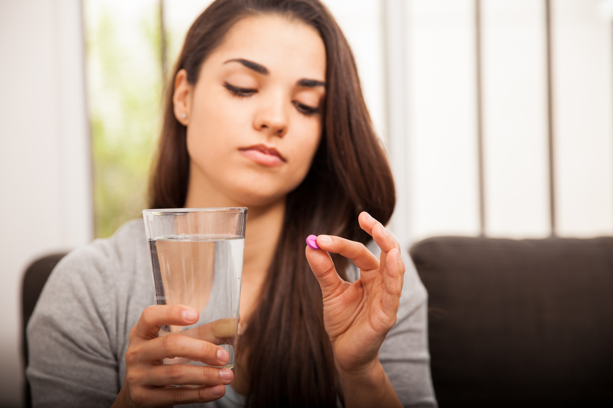 Generic photo of young woman holding a pill and glass of water (Thinkstock/PA)