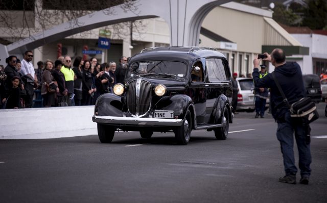 A hearse carrying the casket of Colin Meads is driven through his home town