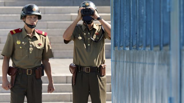 A North Korean army soldier looks at the South side through a pair of binoculars (Jeon Young-Han/AP)