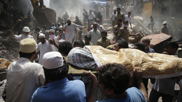 The body of a victim is carried out from the site of a building collapse in Mumbai