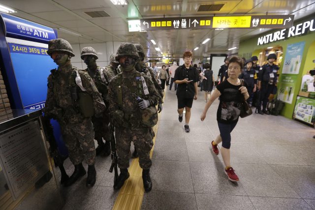 Passengers walk past South Korean army soldiers during an anti-terror drill as part of Ulchi Freedom Guardian exercise inside a subway station in Seoul (Ahn Young-joon/AP)