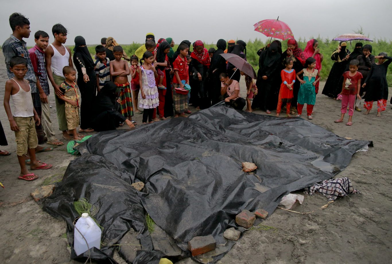 Bangladeshi villagers gather around bodies of Rohingya women and children at Shah Porir Deep, in Teknak, Bangladesh (Suvra Kanti Das/AP)