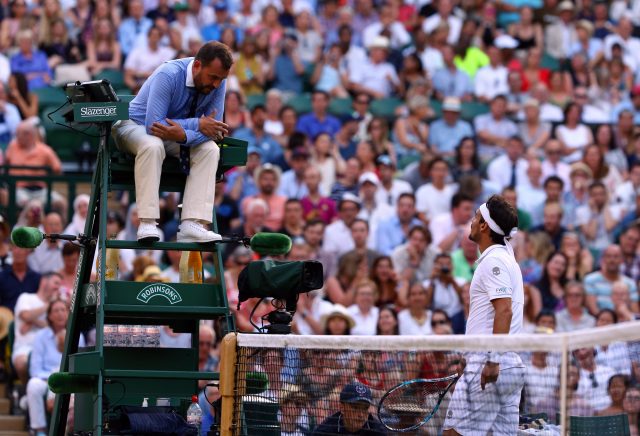 Fabio Fognini is spoken to by the match umpire during this year's Wimbledon