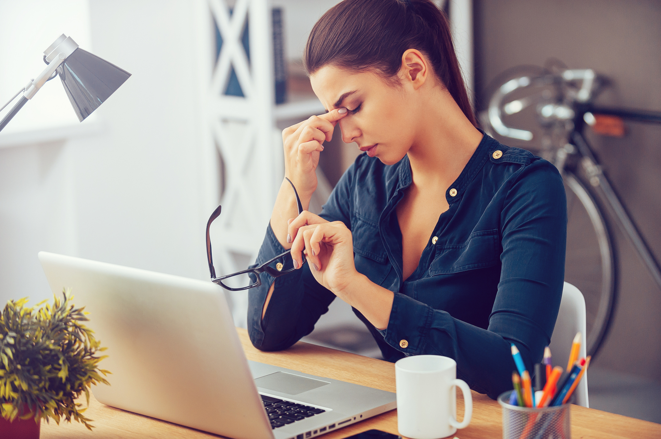 Generic photo of tired-looking woman sat at a desk rubbing her eyes (Thinkstock/PA)