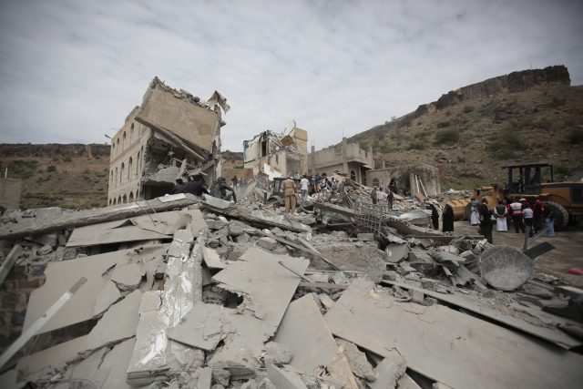 People inspect houses destroyed by Saudi-led air strikes in Sanaa, Yemen