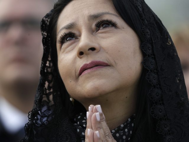 A woman prays during Mass in Bogota's Simon Bolivar Park