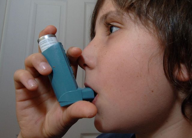 A child using an inhaler for treatment of Asthma