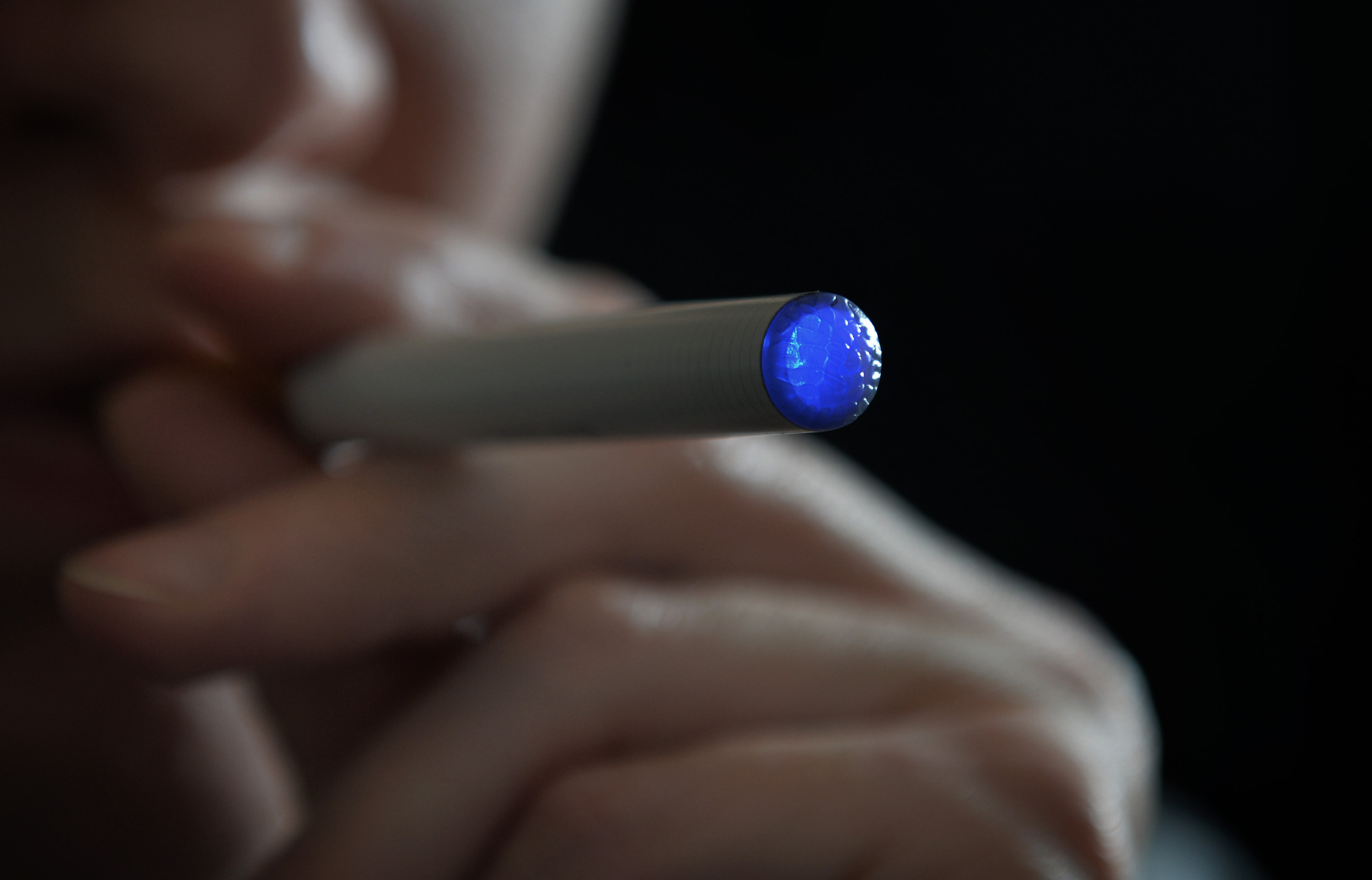  a person smoking an e-cigarette