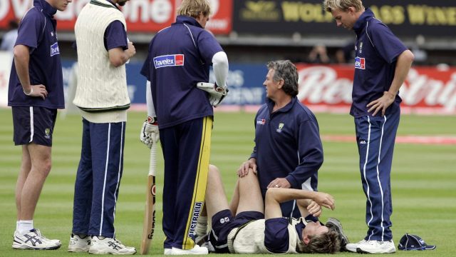 Glenn McGrath is treated after standing on a stray cricket ball at Edgbaston in 2005