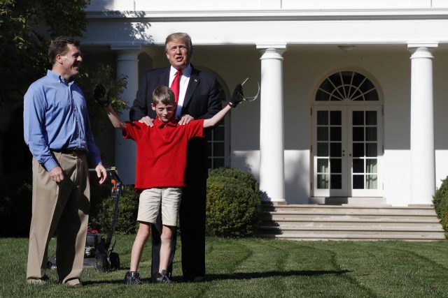 Frank Giaccio, 11, holds up his arms after being surprised by President Donald Trump while he mowed the lawn in the Rose Garden at the White House (Jacquelyn Martin/AP)