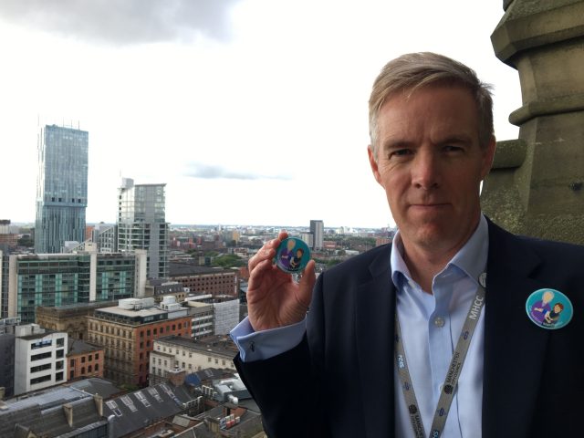 Manchester Health and Care Commissioning chief accountable officer Ian Williamson with the new badge launched by Girlguides in Manchester to tackle loneliness in old people