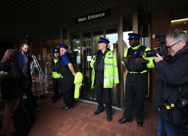 Police stand guard outside the court. (Peter Byrne/PA)