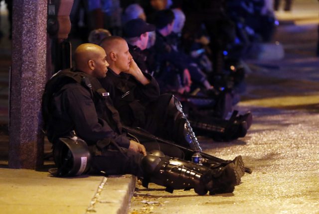 Police rest after multiple arrests were made in St Louis (Jeff Roberson/AP)
