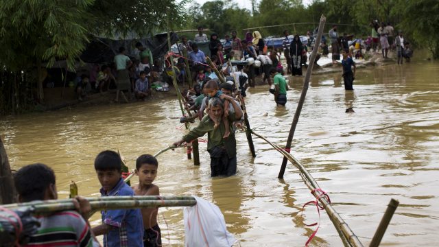 Rohingya Muslims who crossed over recently from Burma into Bangladesh, cross a flooded area to find alternate shelter after their camp was inundated with rainwater near Balukhali refugee camp, Bangladesh (Bernat Armangue/AP)