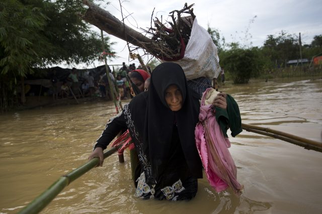 Rohingya Muslims carry their belongings and move to find alternate shelter after rainwater inundated their camp near Balukhali refugee camp in Cox's Bazar, Bangladesh (Bernat Armangue/AP)