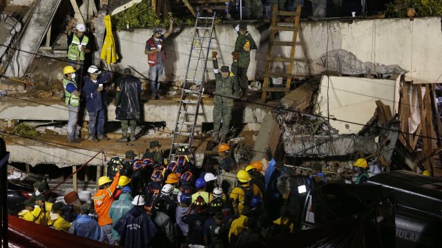 Rescuers try to save a trapped child at a collapsed school in Mexico City