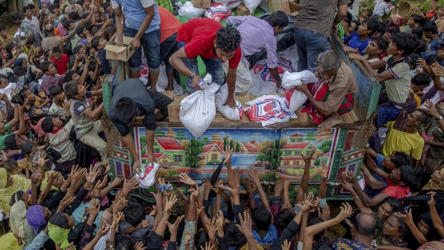 Rohingya Muslims stretch their arms out to collect food items distributed by aid agencies  in Bangladesh (Dar Yasin/AP)