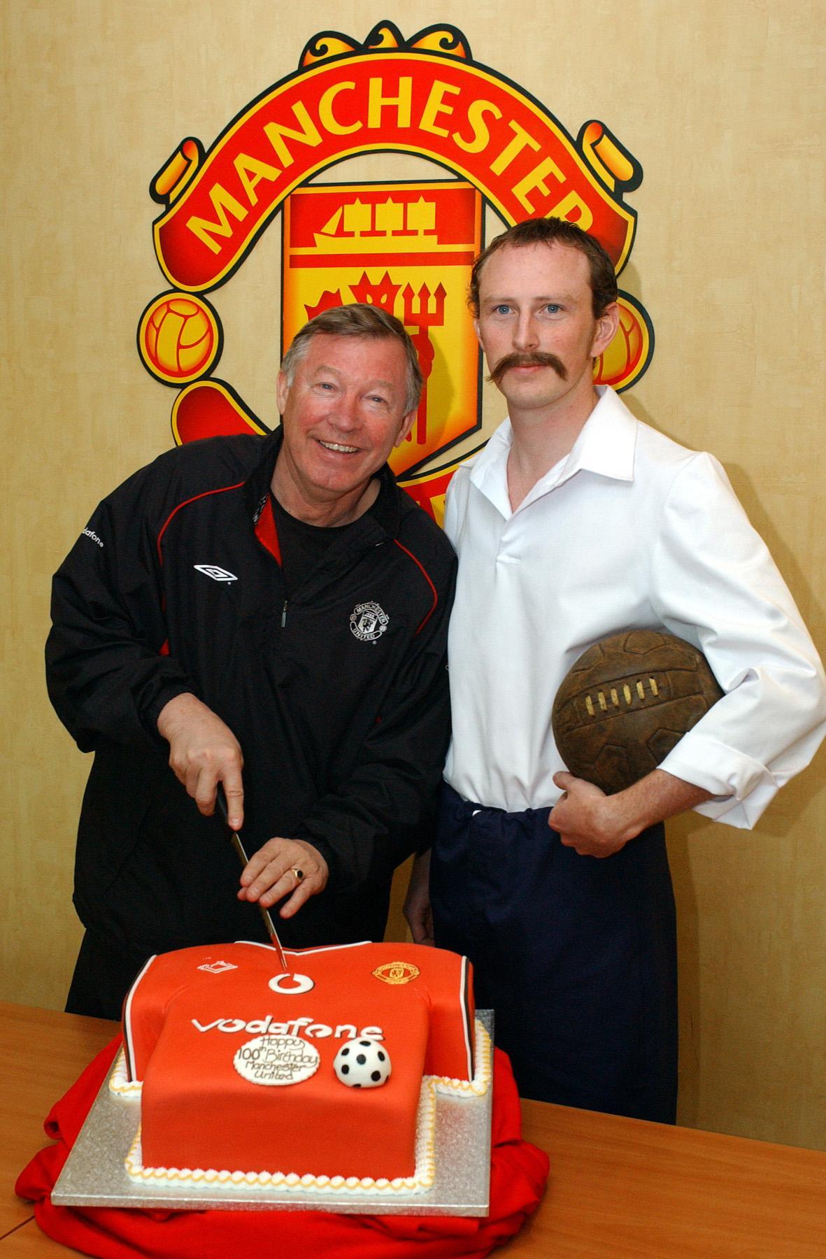 Former Manchester United manager Sir Alex Ferguson cuts a cake to mark the club's 100th anniversary