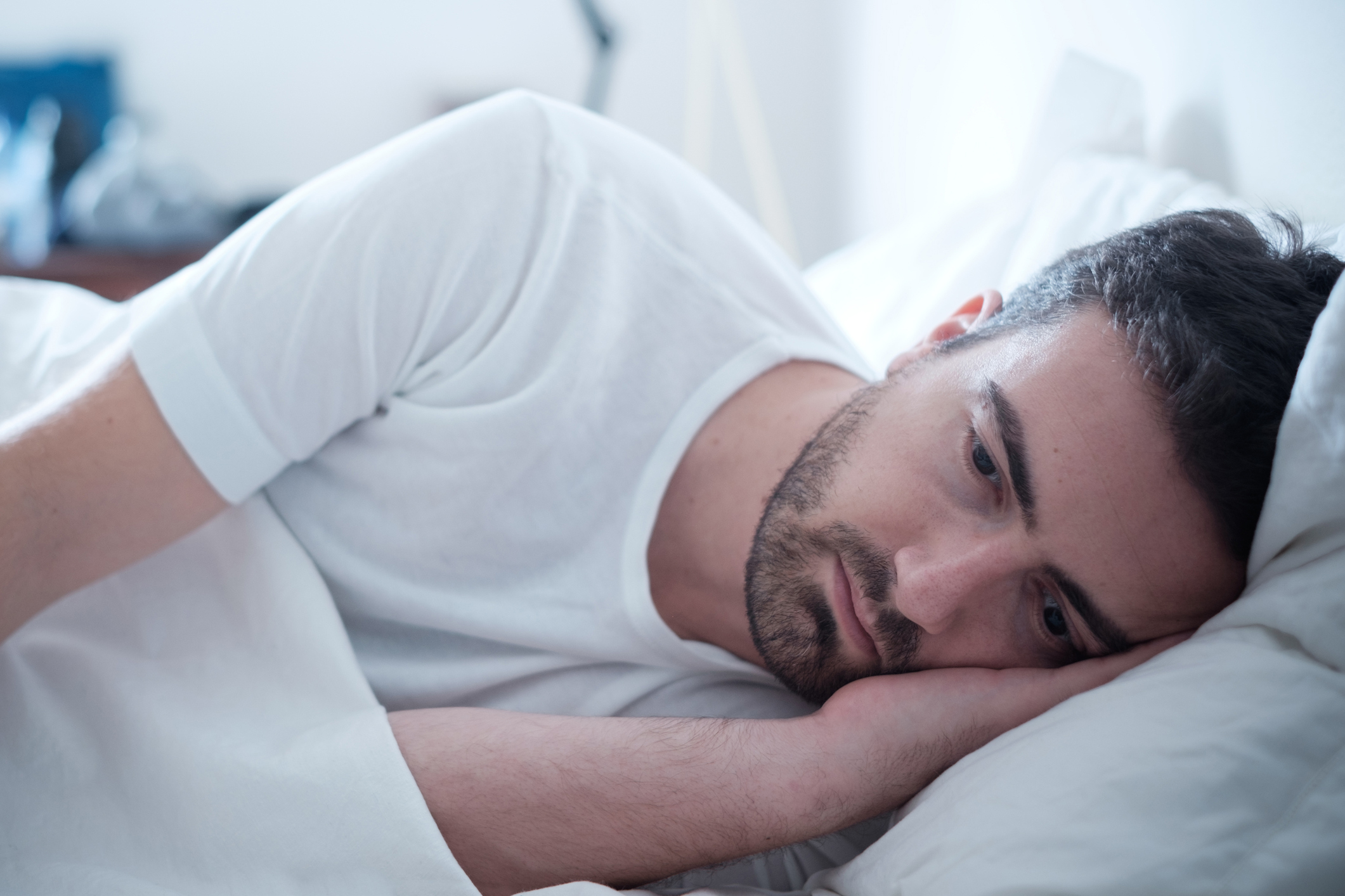 Depressed man lying in his bed.