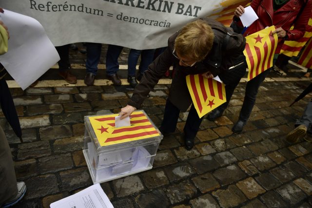 A woman votes in a mock ballot box