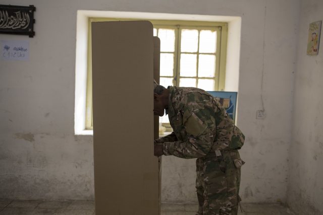 A security guard votes at a polling station in Kirkuk