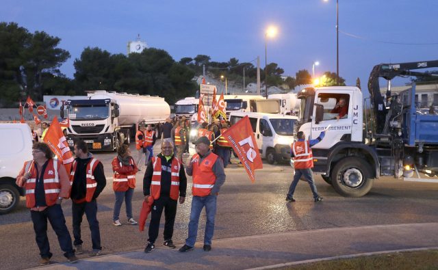 Members of trucker trade unions block access to a refinery