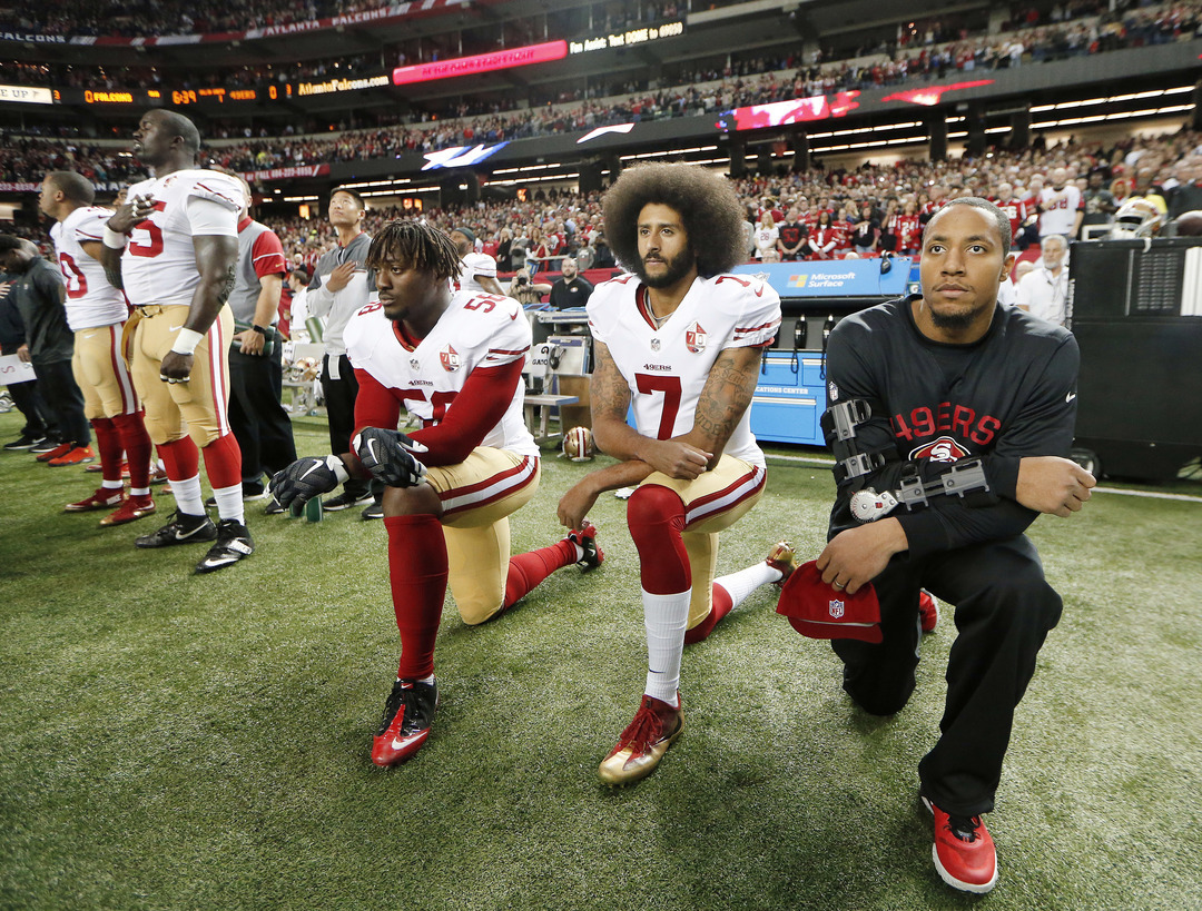 San Francisco 49ers quarterback Colin Kaepernick take a knee