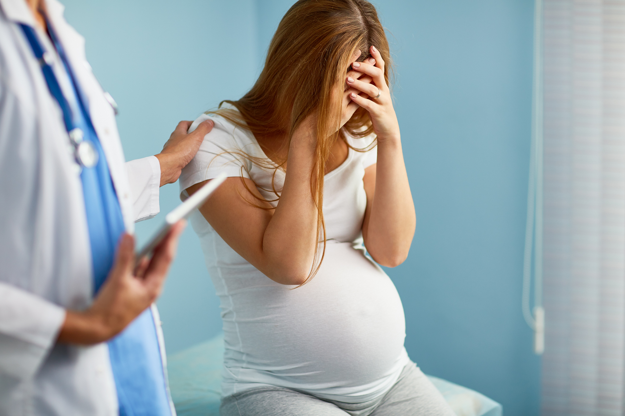 A pregnant woman with her head in her hands being comforted by a doctor (Thinkstock/PA)