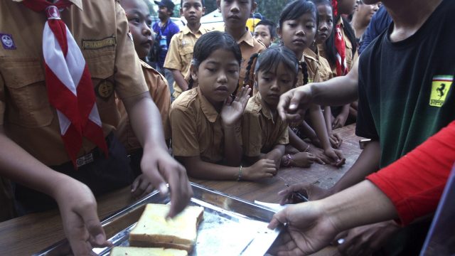 Students queue for a meal at an evacuee camp outside the Mount Agung volcano in Karangasem