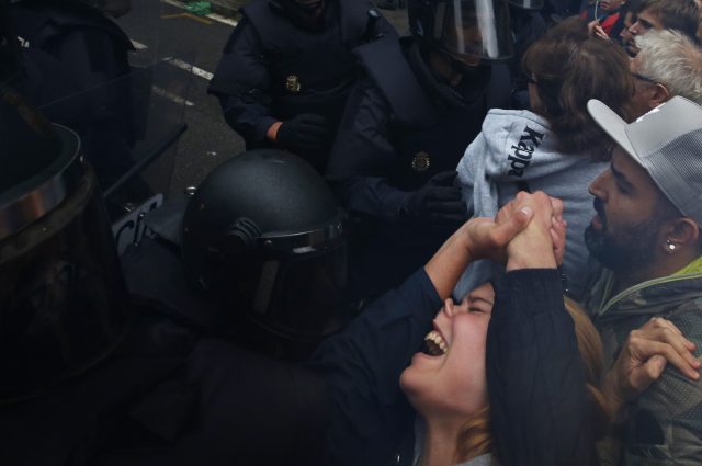 A girls grimaces as Spanish National Police push away Pro-referendum supporters