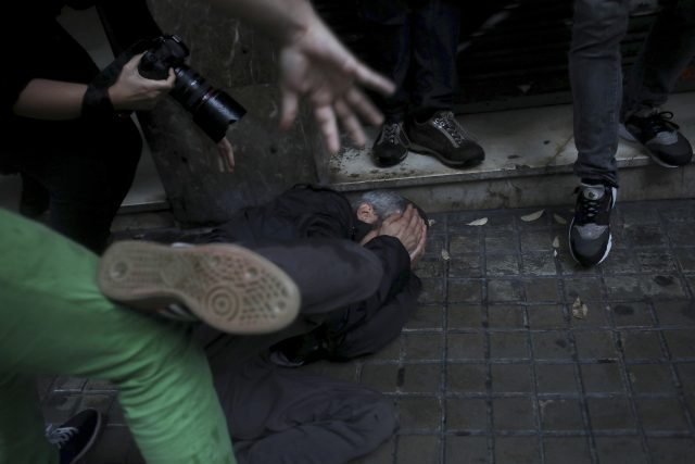 A protester falls on the ground after being hit in the face by a rubber bullet