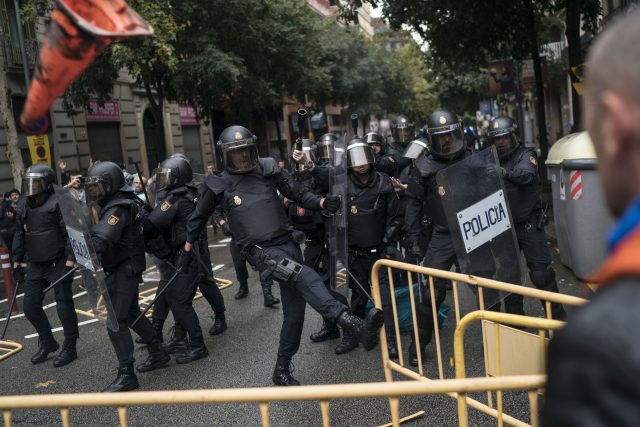 Spanish riot police removes fences thrown by people to them