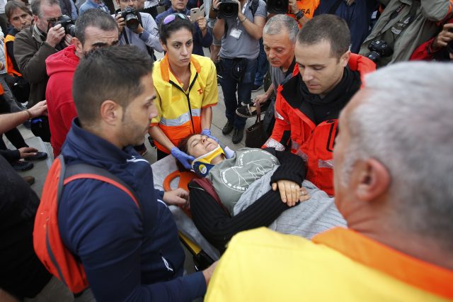 A woman is taken away on a stretcher