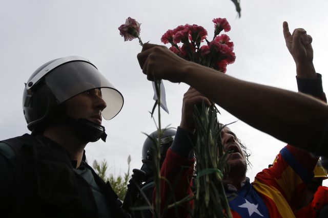 People try to offer flowers to a civil guard