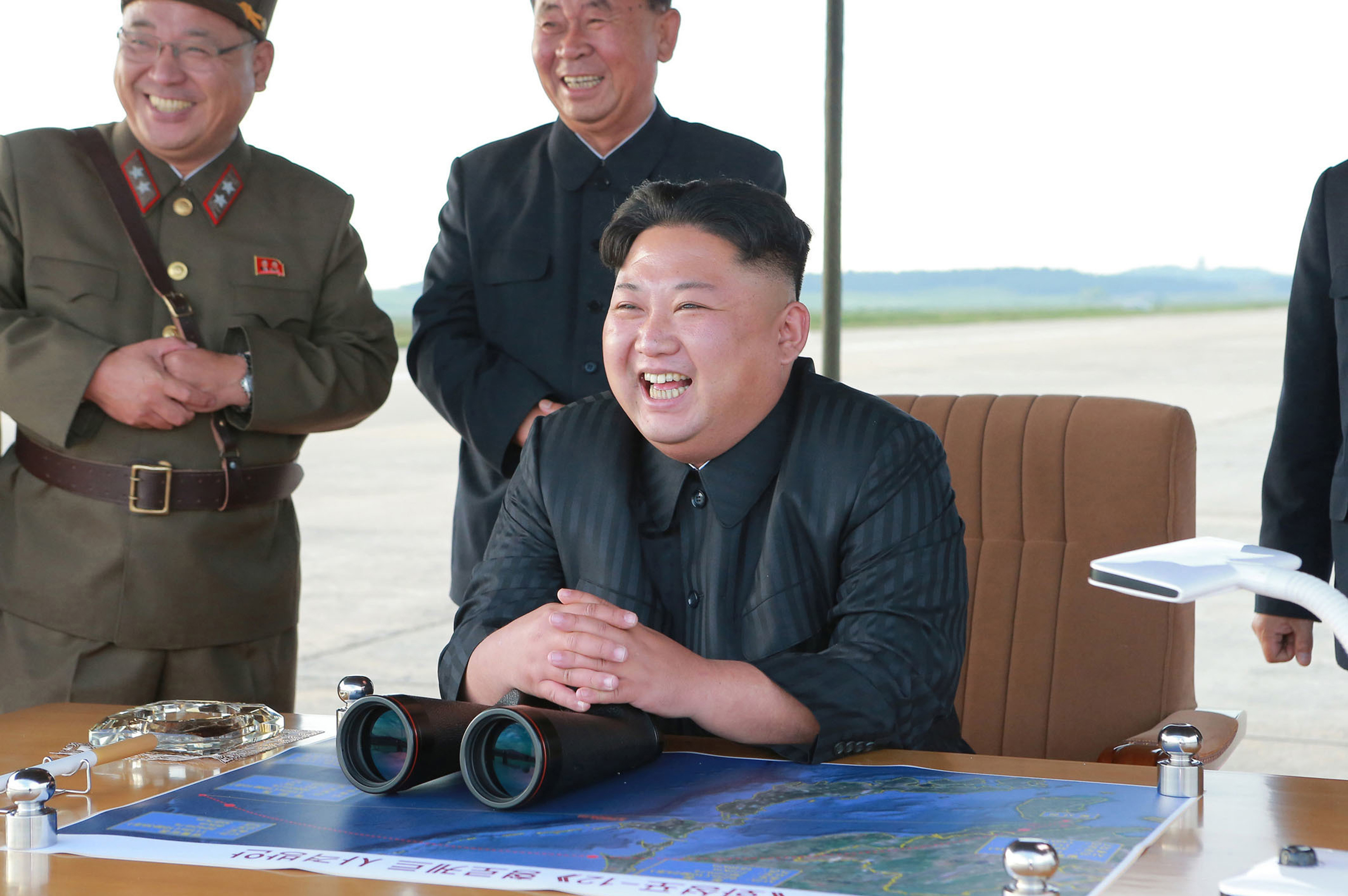 Kim Jong Un laughs at what the North Korean government said was a missile test