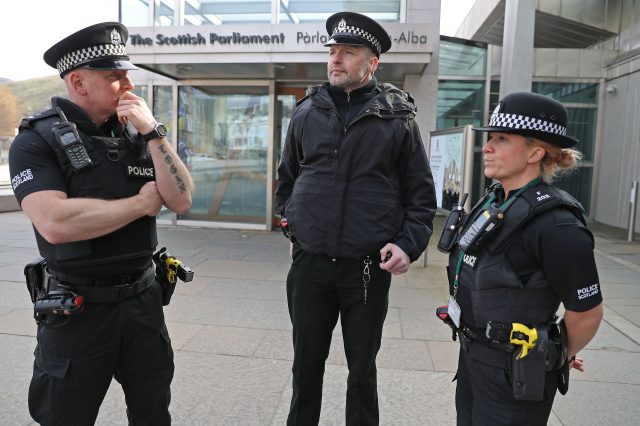 Police officers with Tasers outside Scottish Parliament in Edinburgh. (PA)