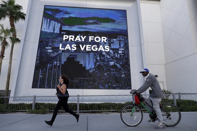 People travel past a sign honouring the victims of a mass shooting in Las Vegas