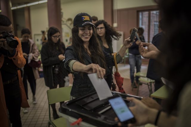 A woman votes at a school listed to be a polling station by the Catalan government in Barcelona