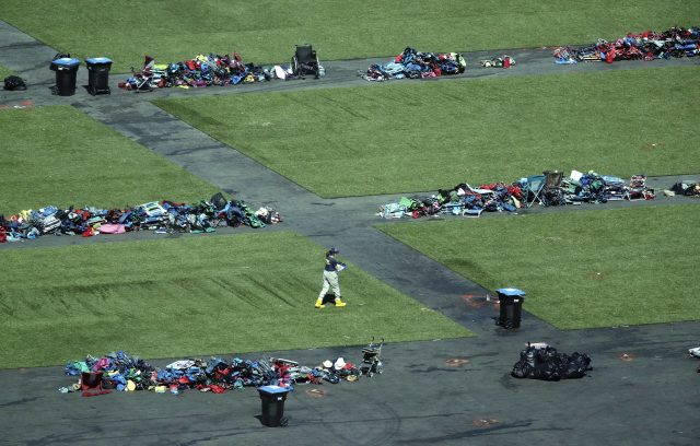 A member of the FBI walks among piles of personal items at the scene of the mass shooting in Las Vegas