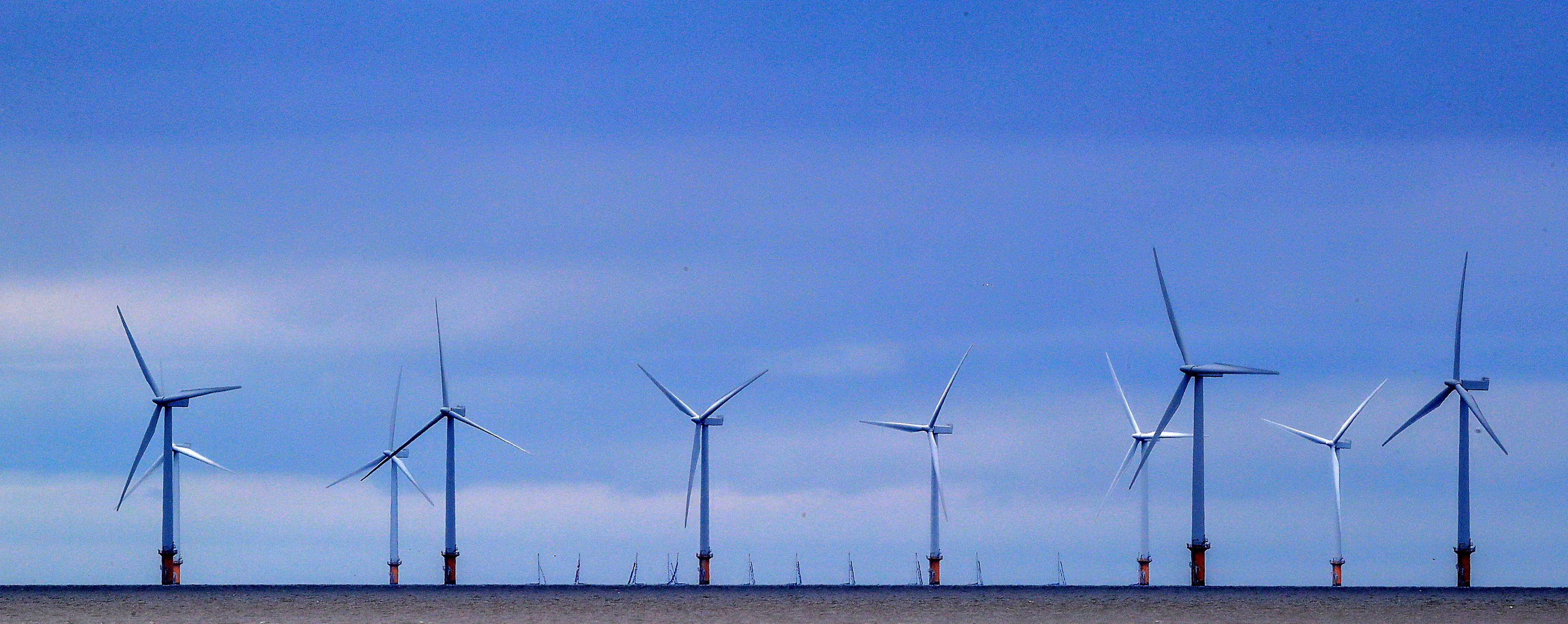  boats sail past the wind farm at the Mersey Bar