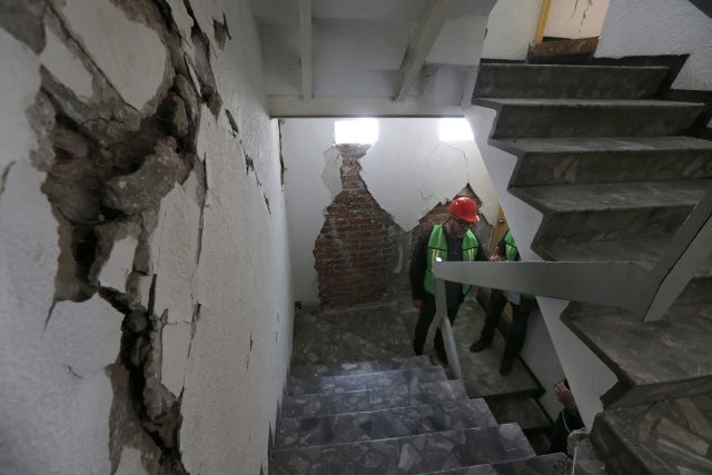 An architect stands in a stairwell during the appraisal of an earthquake-damaged building in Mexico City